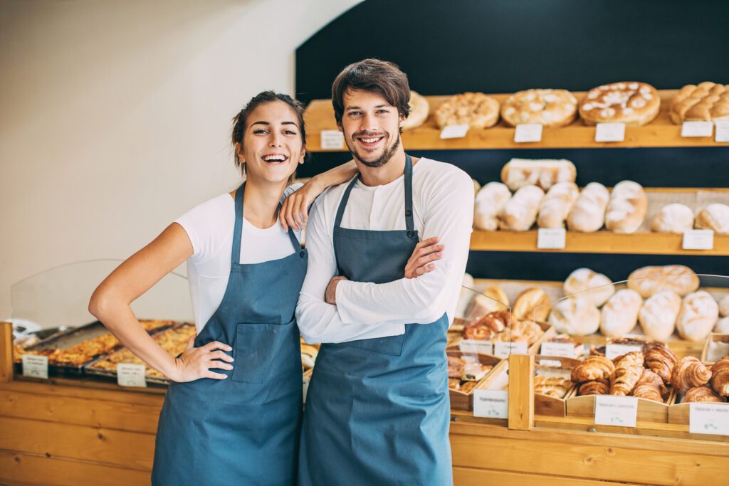 Couple of young bakers in their bread shop.