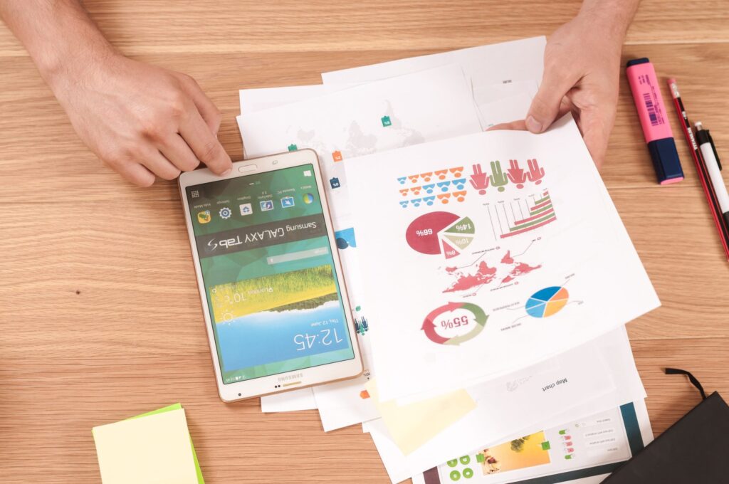 Stack of printed reports next to a mobile phone