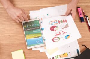 Stack of printed reports next to a mobile phone
