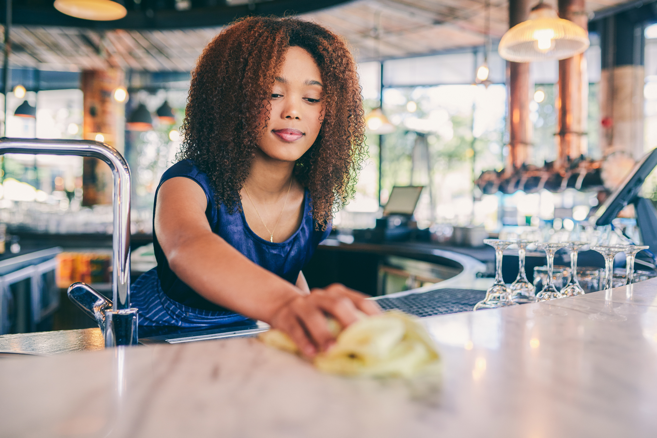 Restaurant worker cleaning the counter in a bar
