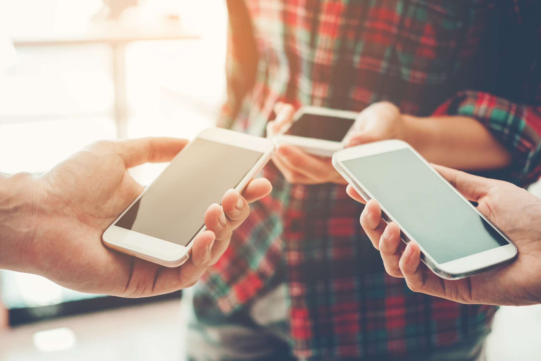 Photo of 3 people holding phones
