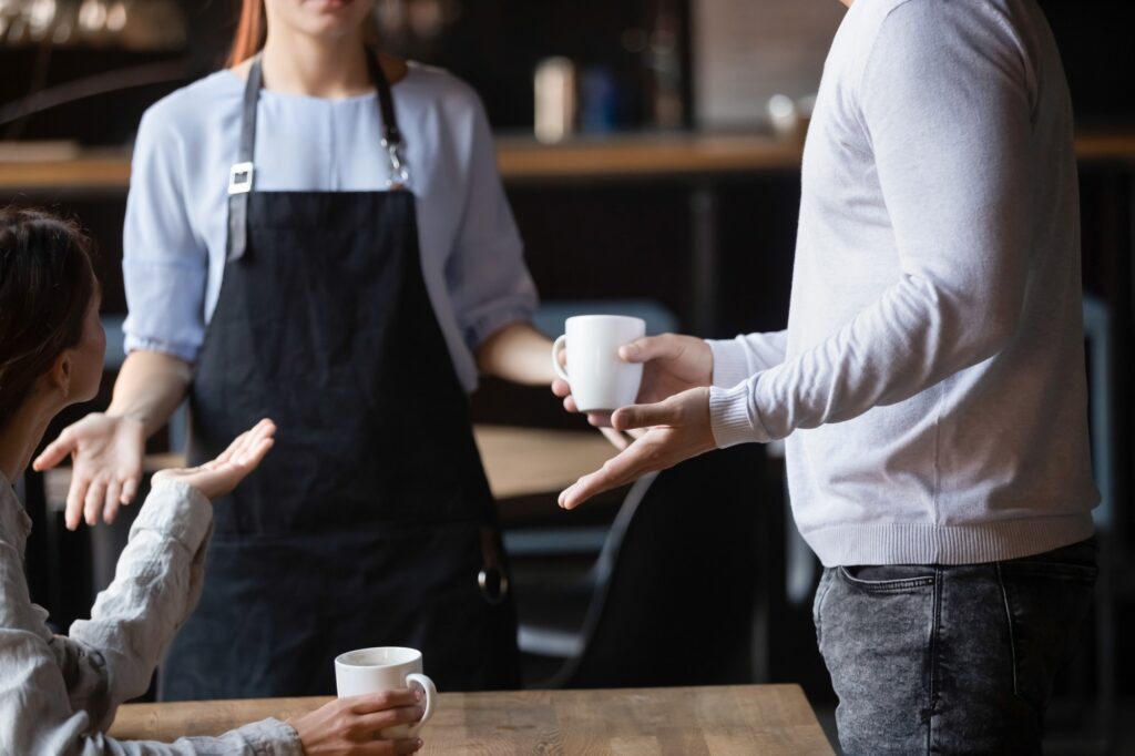 Cafe worker talking with angry customers